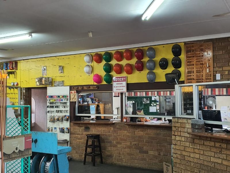 A functional commercial service counter area featuring brickwork detailing, pegboard display walls, and integrated service windows for customer interaction.