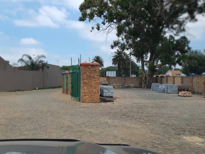 Spacious outdoor yard area featuring perimeter brick walling, secure gated entrance, and paved ground surface suitable for commercial storage or parking.