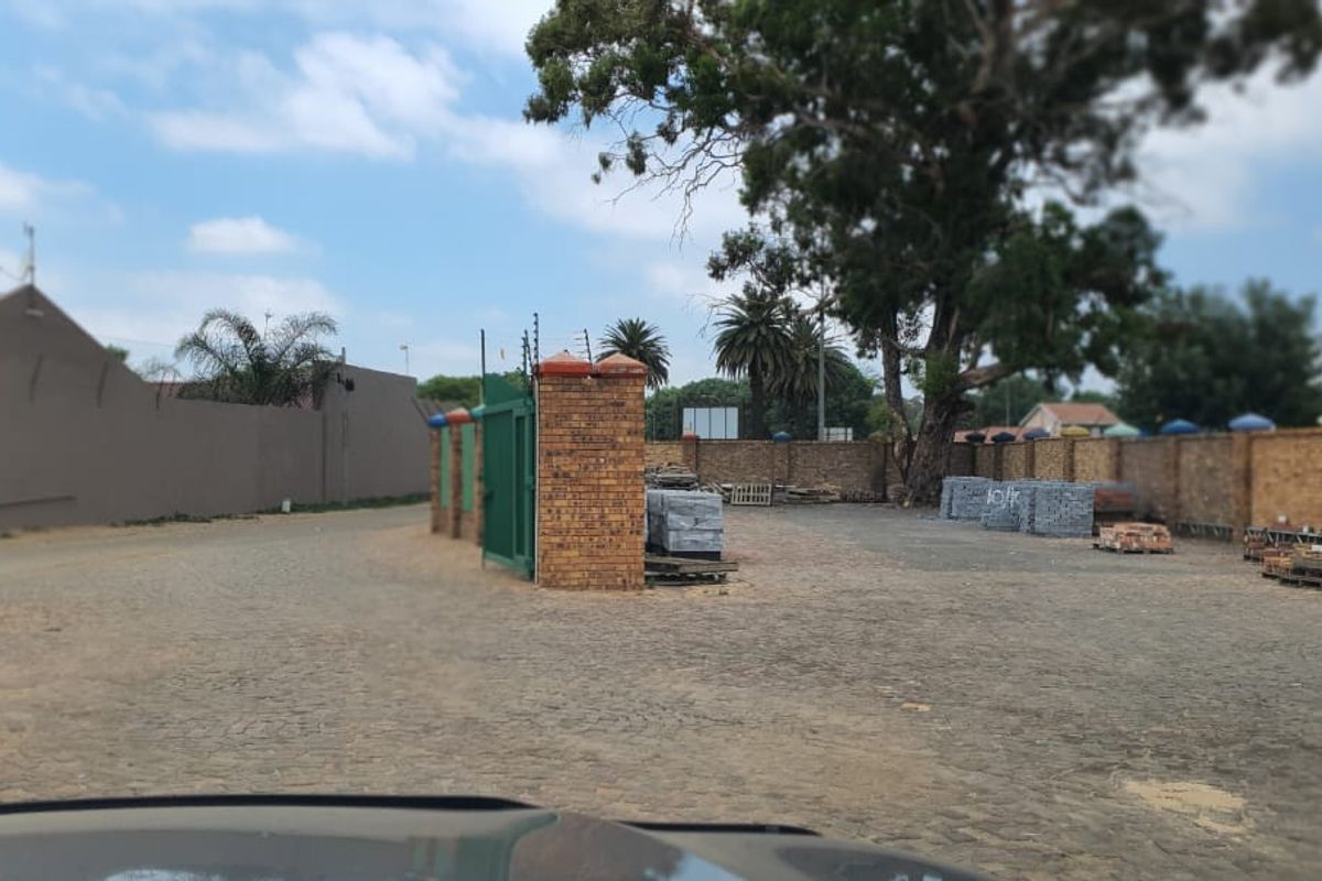 Spacious outdoor yard area featuring perimeter brick walling, secure gated entrance, and paved ground surface suitable for commercial storage or parking.