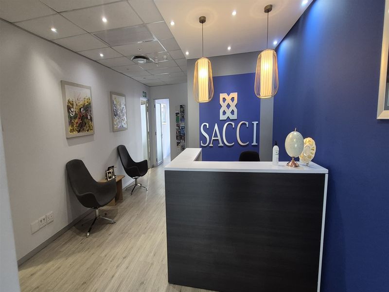 Professional office reception area featuring a modern reception desk, pendant lighting, and clean finishes, creating a welcoming entrance for clients.