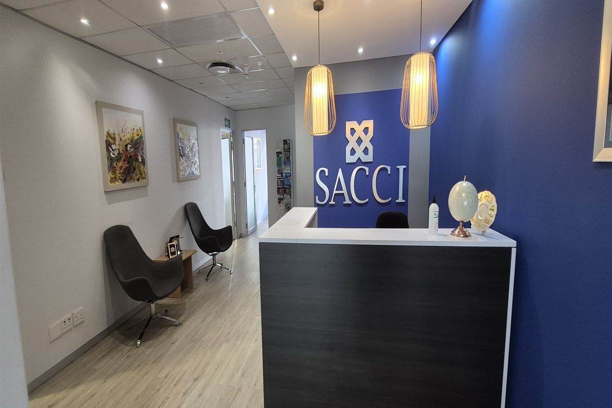 Professional office reception area featuring a modern reception desk, pendant lighting, and clean finishes, creating a welcoming entrance for clients.