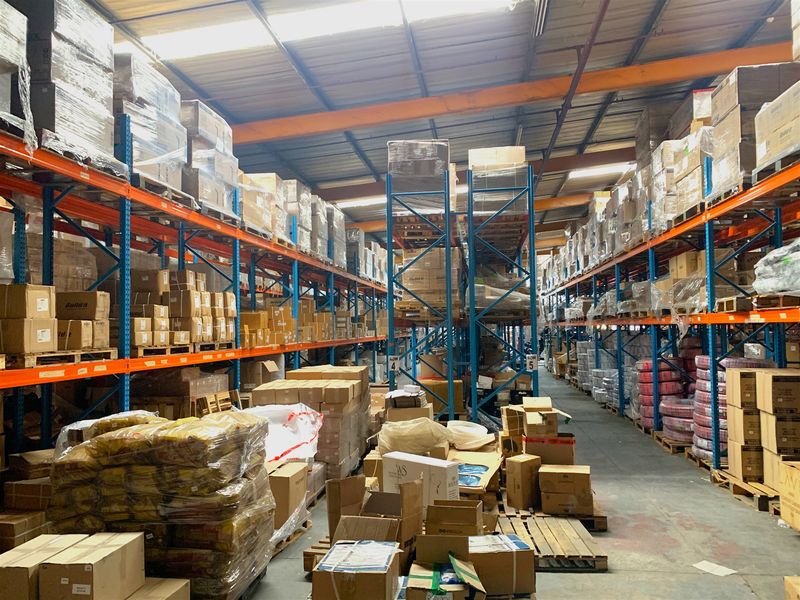 Spacious industrial warehouse featuring high-clearance steel racking systems, exposed roof trusses, and durable concrete flooring, optimized for large-scale storage and logistics operations.