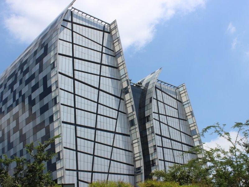 Modern commercial office building featuring a striking geometric glass facade and contemporary architectural design.