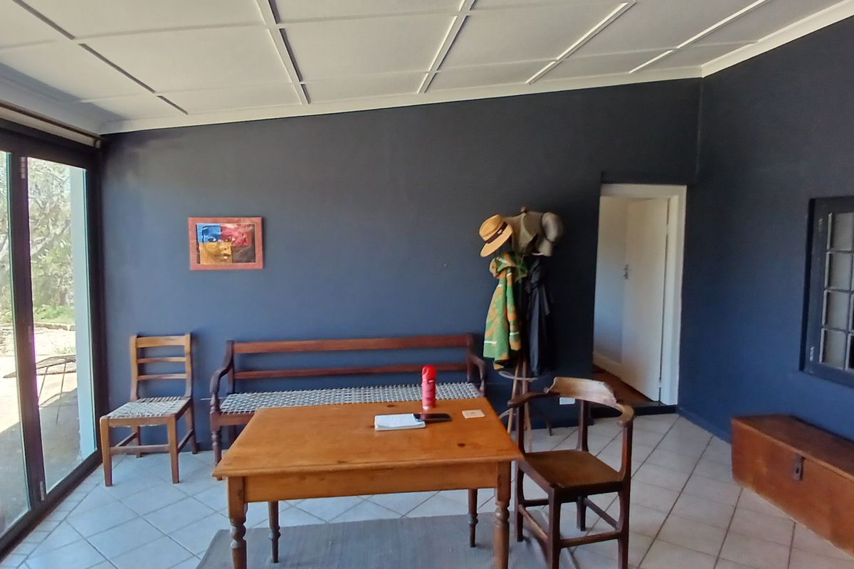 A living area featuring dark painted walls, tiled flooring, and large sliding glass doors that provide natural light and access to the outdoors.