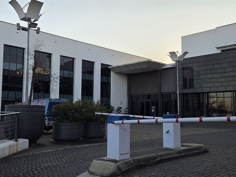Front exterior view of a modern office building at 345 Rivonia Road, featuring a secure gated entrance and contemporary glass facade.
