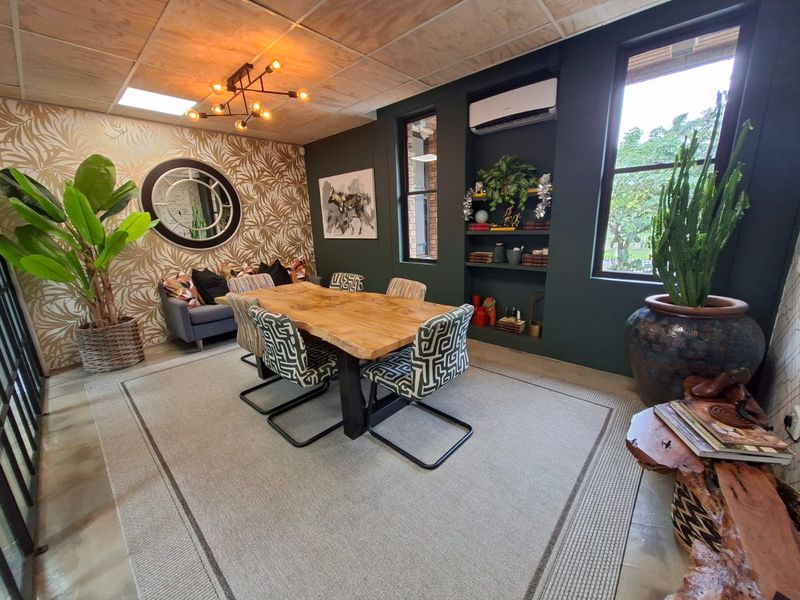 A well-appointed office space featuring a plywood ceiling, recessed shelving, and a wall-mounted air conditioning unit.