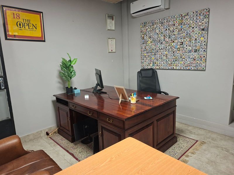 A professional office space featuring tiled flooring, neutral wall finishes, and a wall-mounted air conditioning unit.