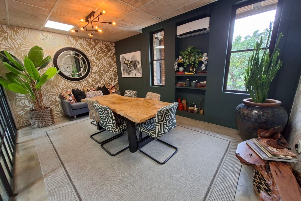 A well-appointed office space featuring a plywood ceiling, recessed shelving, and a wall-mounted air conditioning unit.