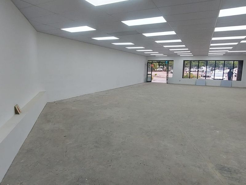 Spacious open-plan retail unit featuring a suspended ceiling with recessed lighting, large display windows, and a dedicated electrical distribution board.