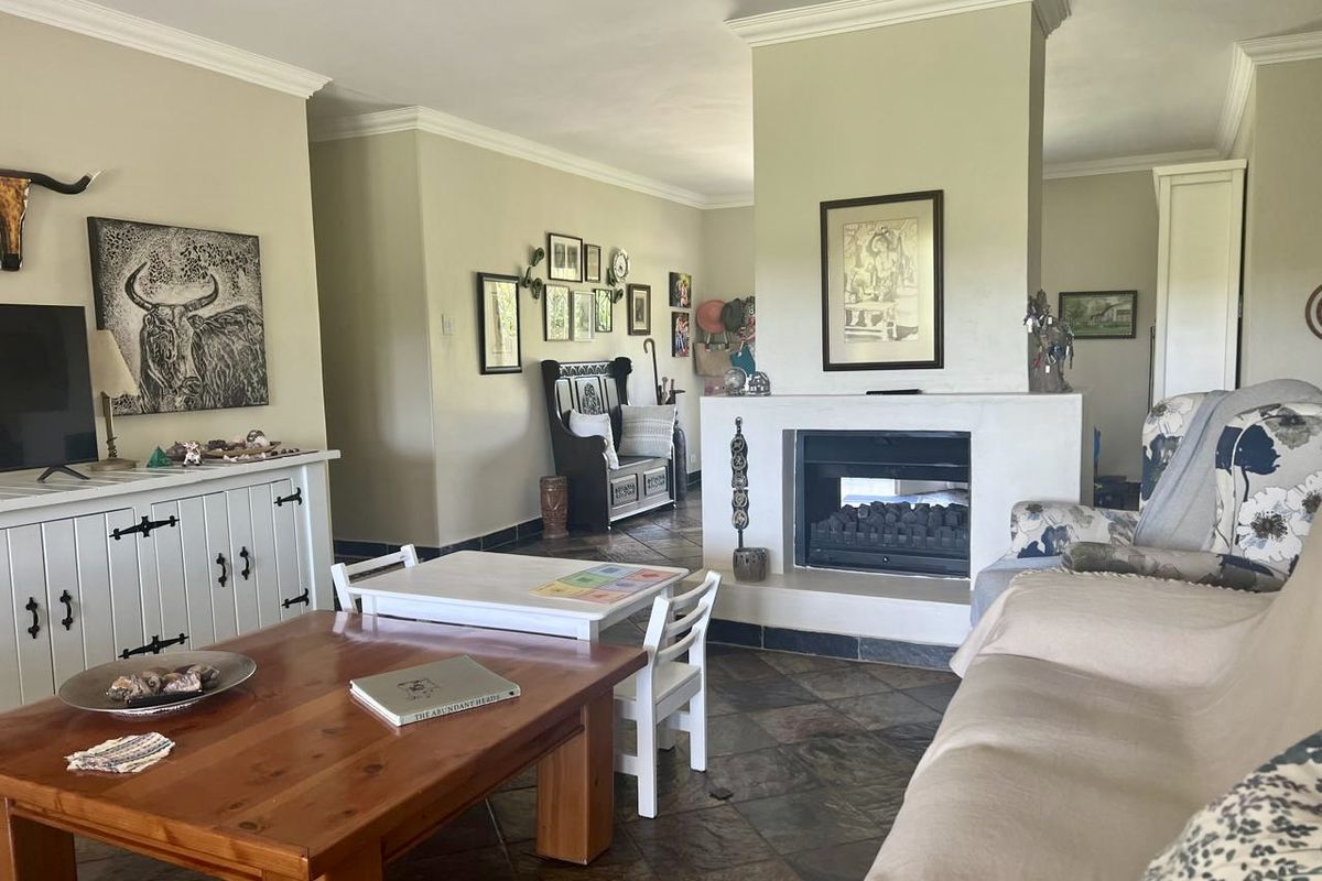Spacious living room featuring a central built-in fireplace, slate tile flooring, and crown molding, creating a warm and inviting atmosphere.