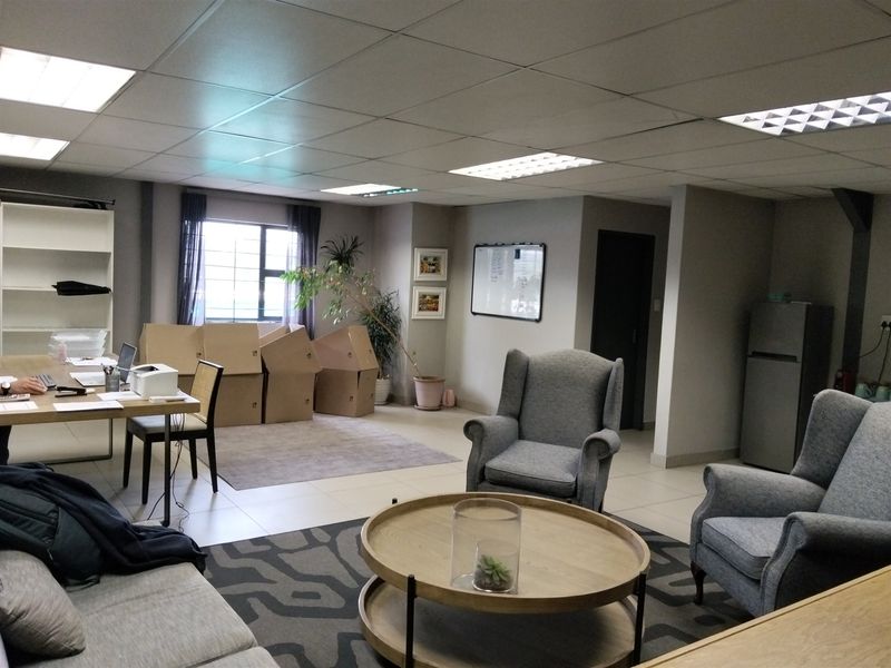 A functional office space featuring a suspended ceiling with recessed lighting and tiled flooring, suitable for a professional work environment.