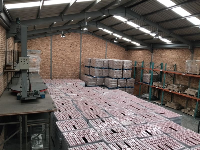 Spacious industrial warehouse featuring exposed brick walls, steel portal frame construction, integrated skylights, and heavy-duty pallet racking for efficient storage.