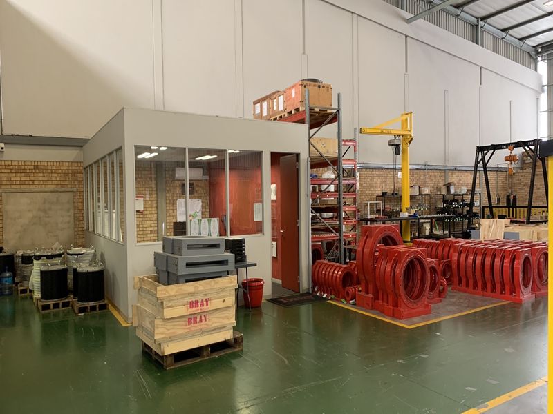 Industrial warehouse space featuring an enclosed office, epoxy flooring, and integrated lifting equipment including a jib crane and gantry crane.