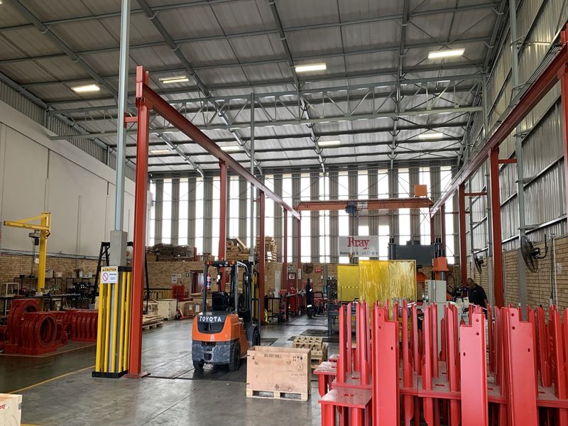 Spacious industrial warehouse facility featuring high ceilings, exposed steel portal frame construction, overhead crane system, and durable concrete flooring suitable for manufacturing or storage.