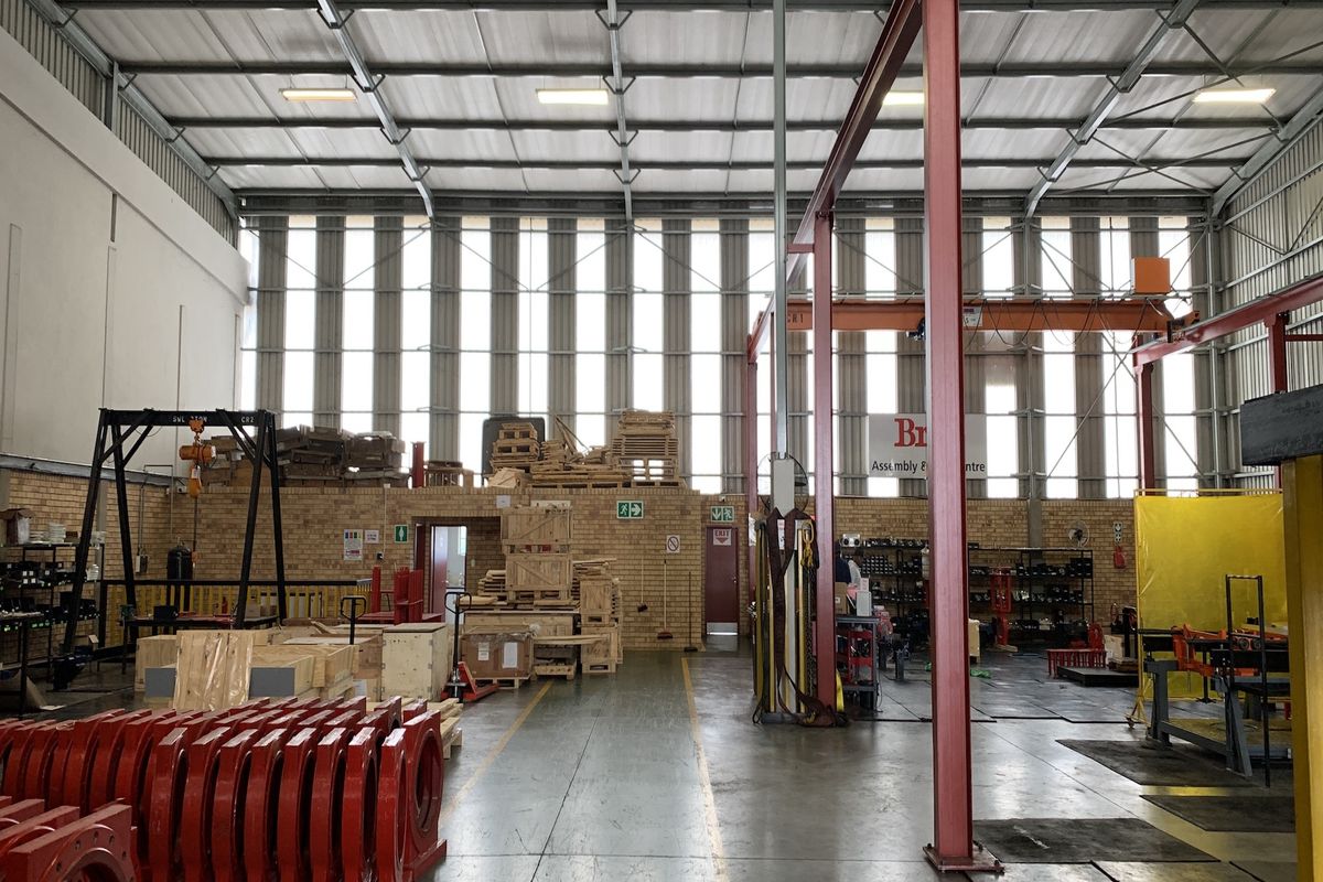 Spacious industrial warehouse facility featuring high ceilings, exposed steel portal frame, overhead gantry crane, and durable concrete flooring suitable for manufacturing or storage operations.