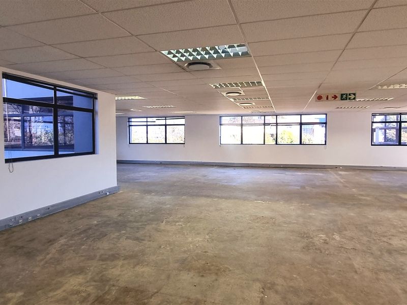A large, open-plan office space featuring suspended ceilings, recessed lighting, and expansive windows, currently in a shell condition ready for fit-out.