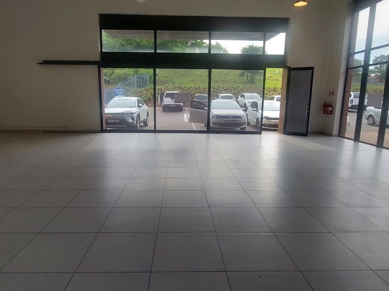 Spacious open-plan retail unit featuring large glass storefront windows, tiled flooring, and high ceilings, offering excellent visibility and natural light.