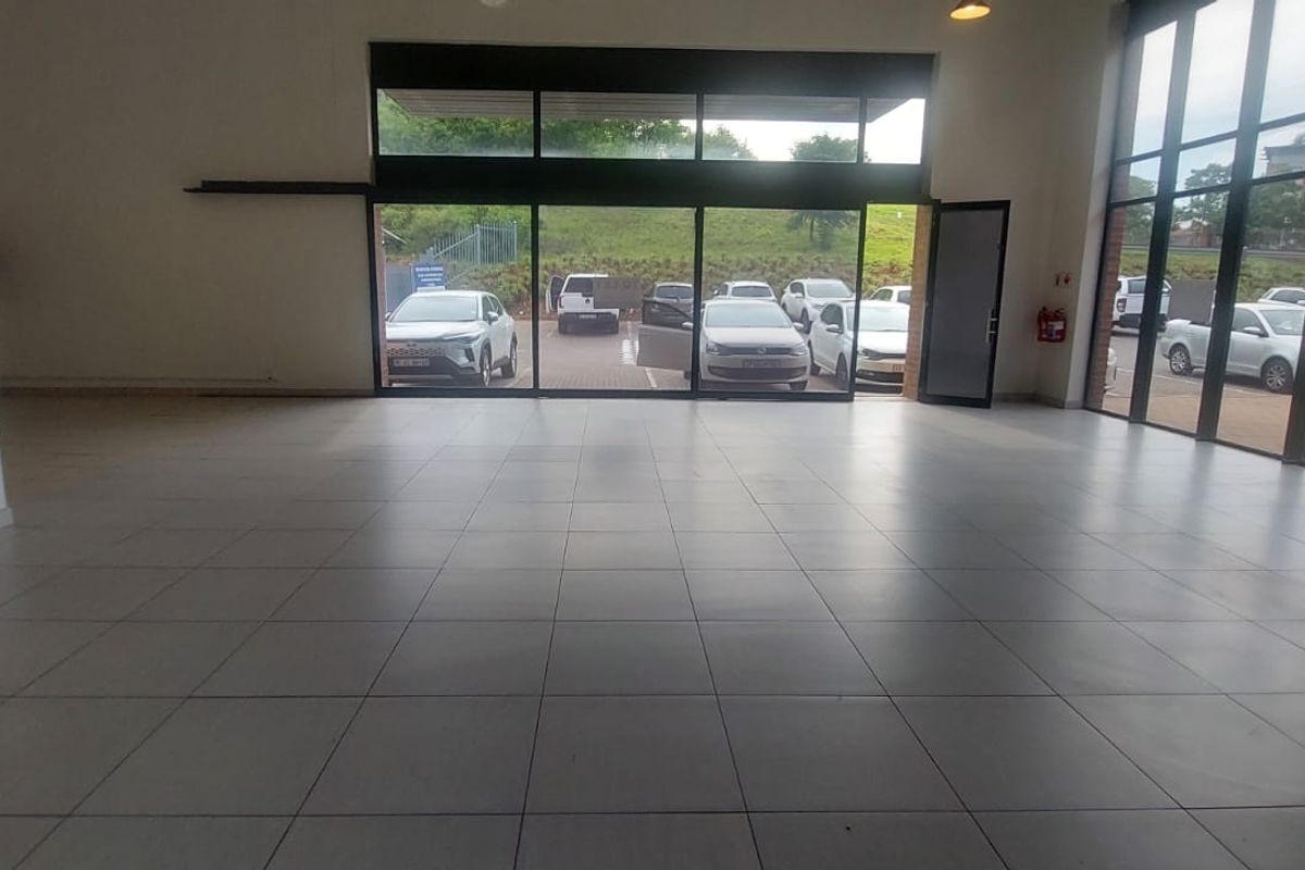 Spacious open-plan retail unit featuring large glass storefront windows, tiled flooring, and high ceilings, offering excellent visibility and natural light.
