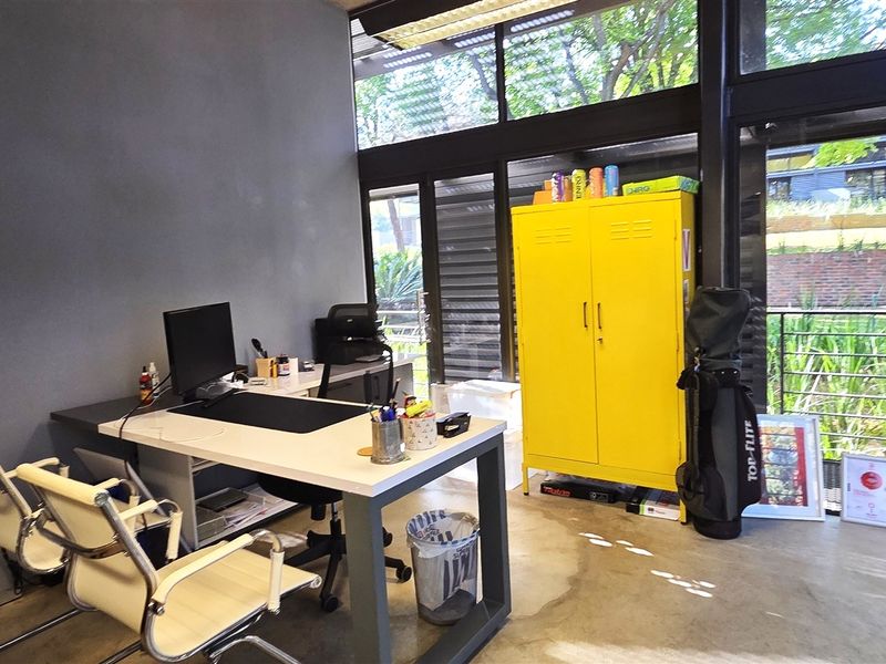 A modern office space featuring polished concrete floors and expansive floor-to-ceiling windows that provide ample natural light and views of the exterior.