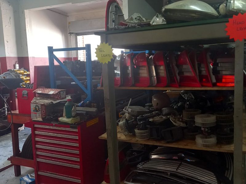 A functional industrial utility space or workshop area featuring concrete flooring and fixed storage shelving, suitable for commercial or automotive storage purposes.