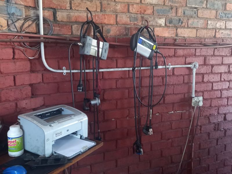 Utility area featuring exposed brick walls and surface-mounted electrical conduit with power outlets.
