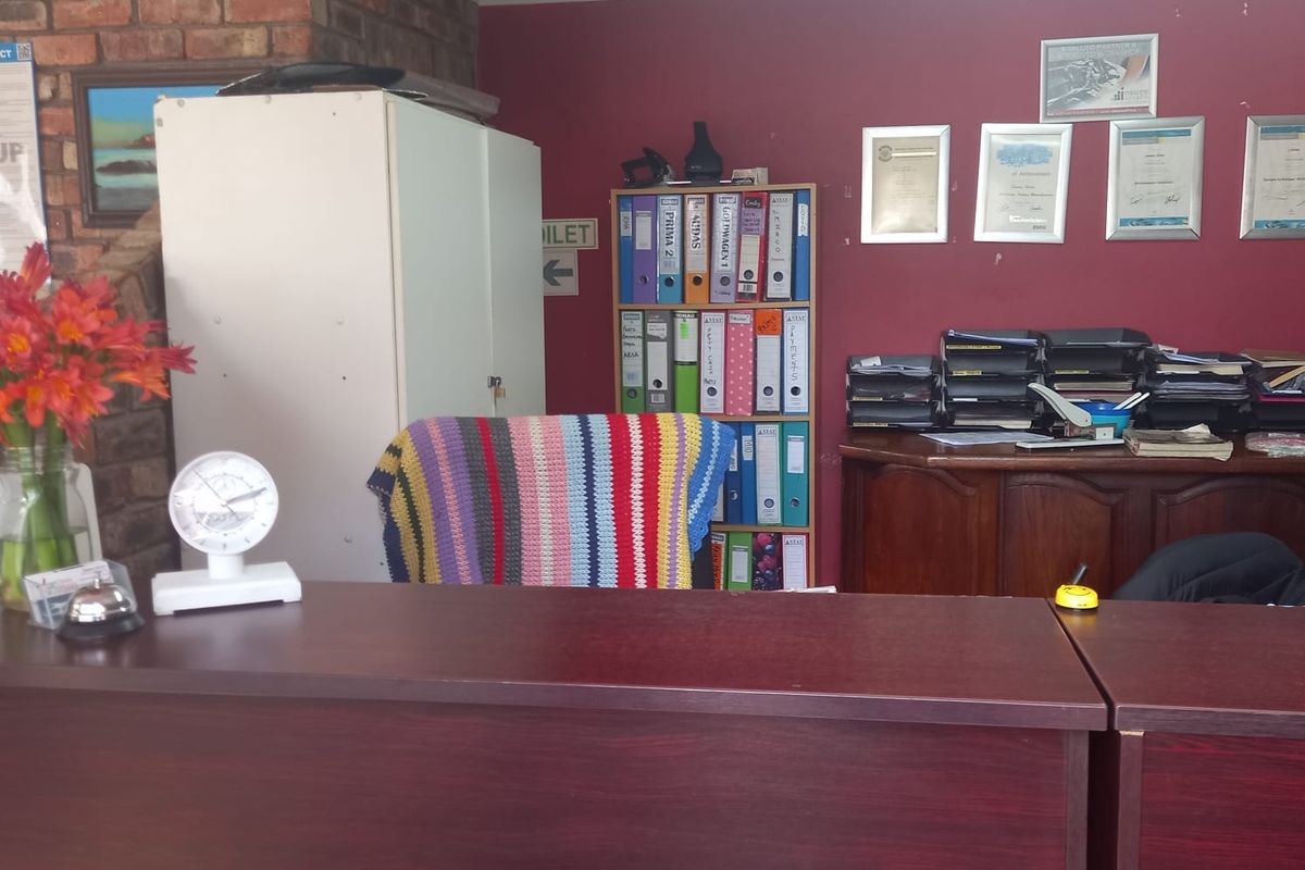 A functional office reception area featuring a built-in desk, exposed brick accents, and painted walls, suitable for a professional business environment.