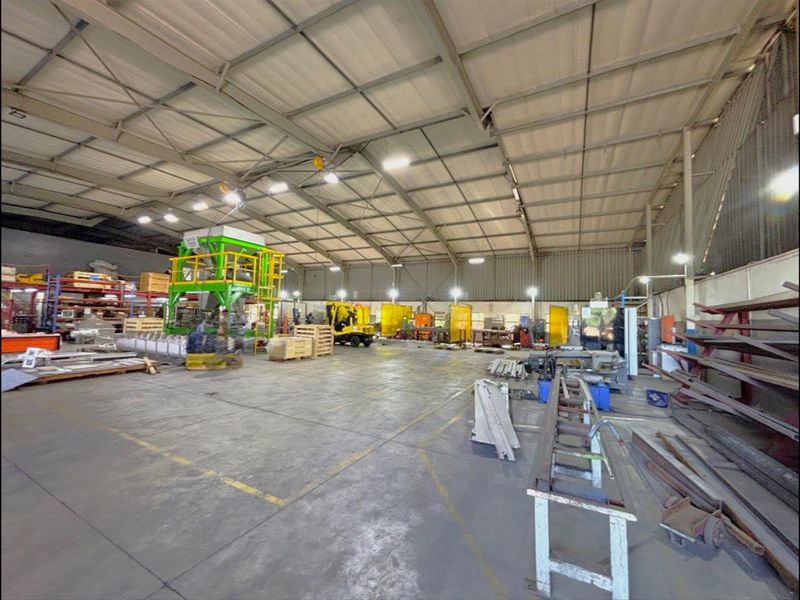 Spacious industrial warehouse featuring a high-clearance steel portal frame, concrete flooring, and overhead crane infrastructure suitable for manufacturing or storage operations.