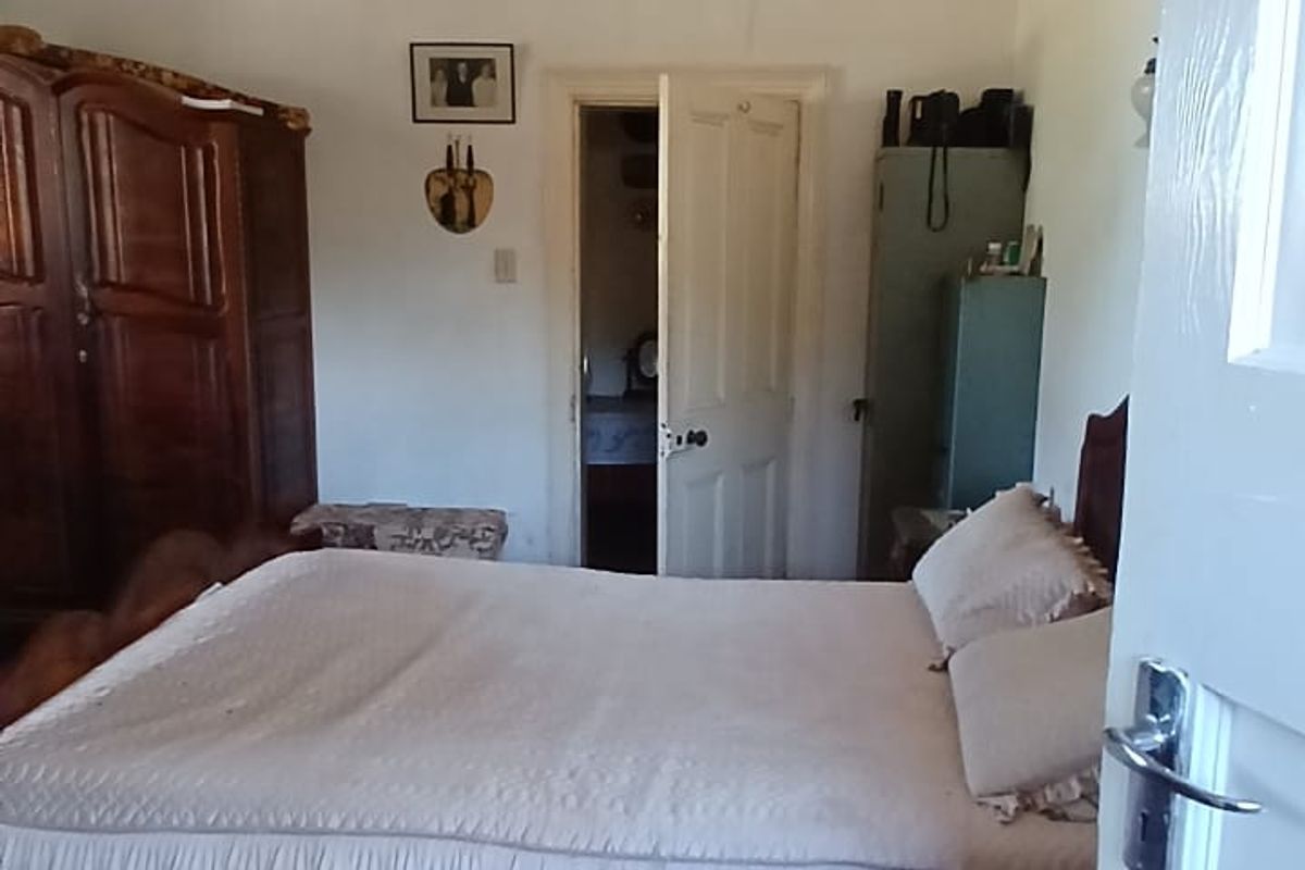 A bedroom featuring a coffered ceiling and dated carpet flooring, offering a functional space with potential for cosmetic updates.