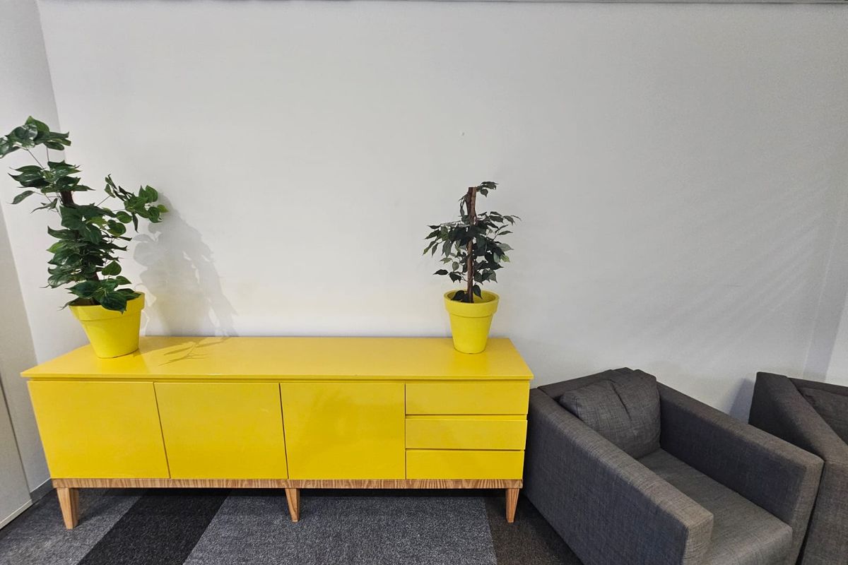 A functional office space featuring a suspended ceiling and carpeted flooring, providing a clean and professional environment for business operations.