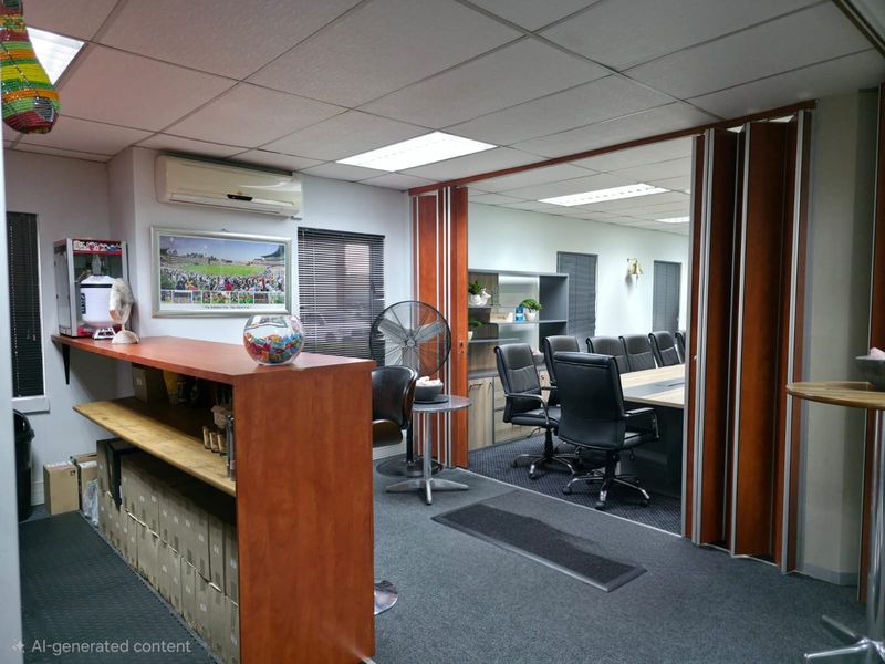Office space featuring a reception counter, carpeted flooring, drop ceiling with recessed lighting, and a folding partition door leading to a conference room.