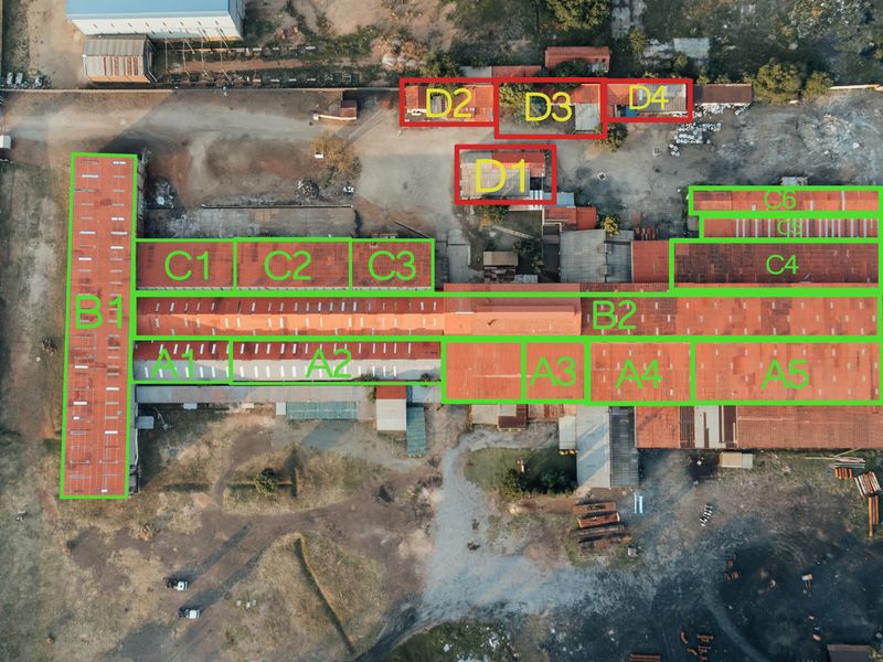 Aerial view of an industrial property complex featuring multiple warehouse structures, metal roofing, and extensive yard space for logistics or manufacturing operations.