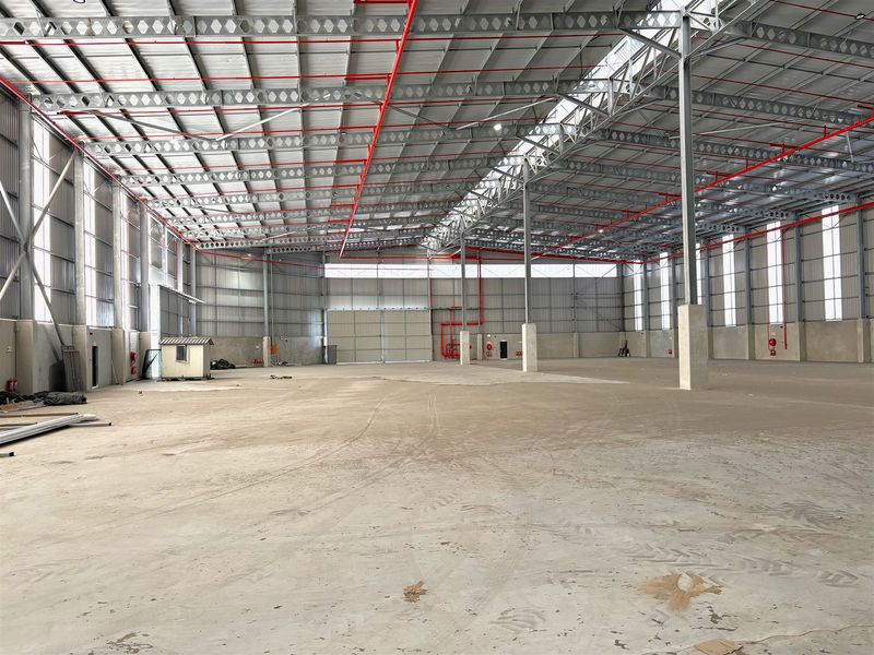 Spacious industrial warehouse featuring a high-clearance steel portal frame, polished concrete flooring, and an integrated fire sprinkler system.