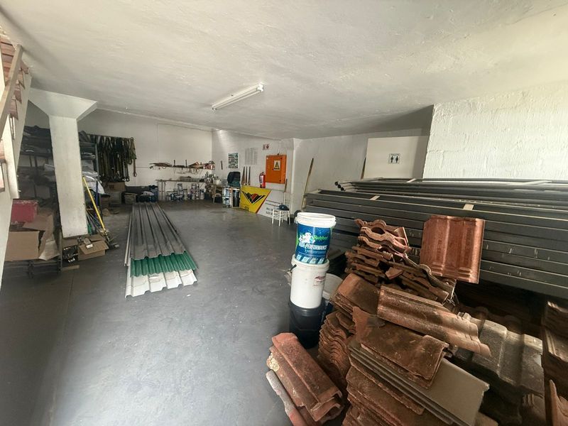 A functional industrial utility or storage space featuring concrete flooring, overhead lighting, and basic wall finishes, suitable for workshop or warehouse use.