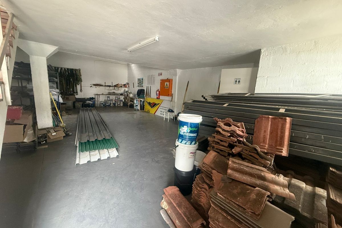 A functional industrial utility or storage space featuring concrete flooring, overhead lighting, and basic wall finishes, suitable for workshop or warehouse use.