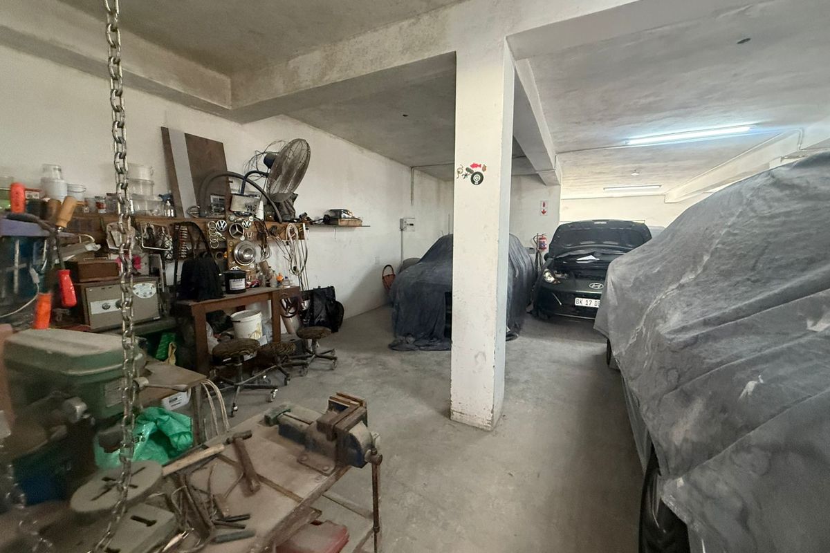 Spacious industrial garage area featuring concrete flooring, structural support columns, and ample room for vehicle storage or workshop activities.