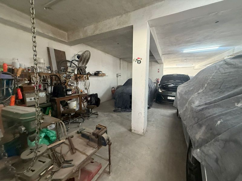 Spacious industrial garage area featuring concrete flooring, structural support columns, and ample room for vehicle storage or workshop activities.