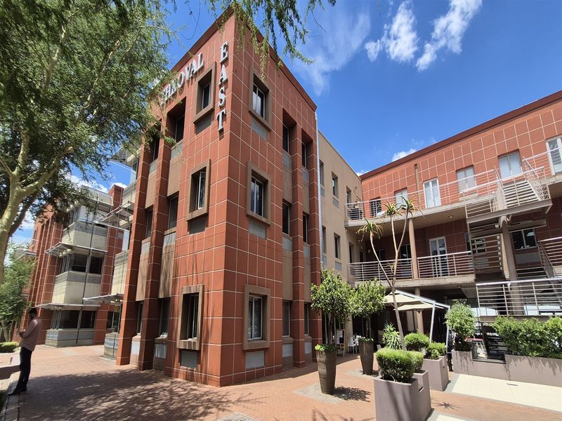 Exterior view of the multi-story office building featuring a brick facade, paved courtyard area, and external metal staircases.