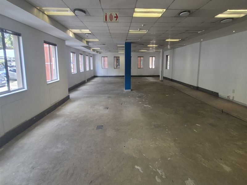 A large, vacant open-plan office space featuring a suspended ceiling, recessed lighting, and exposed concrete flooring, ready for custom fit-out.