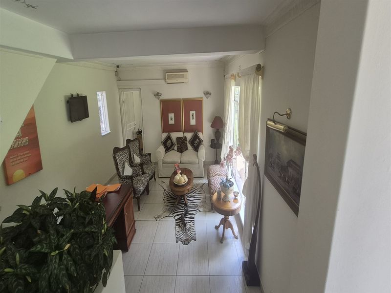 A well-lit office space featuring tiled flooring, crown molding, and wall-mounted air conditioning, providing a professional and comfortable work environment.