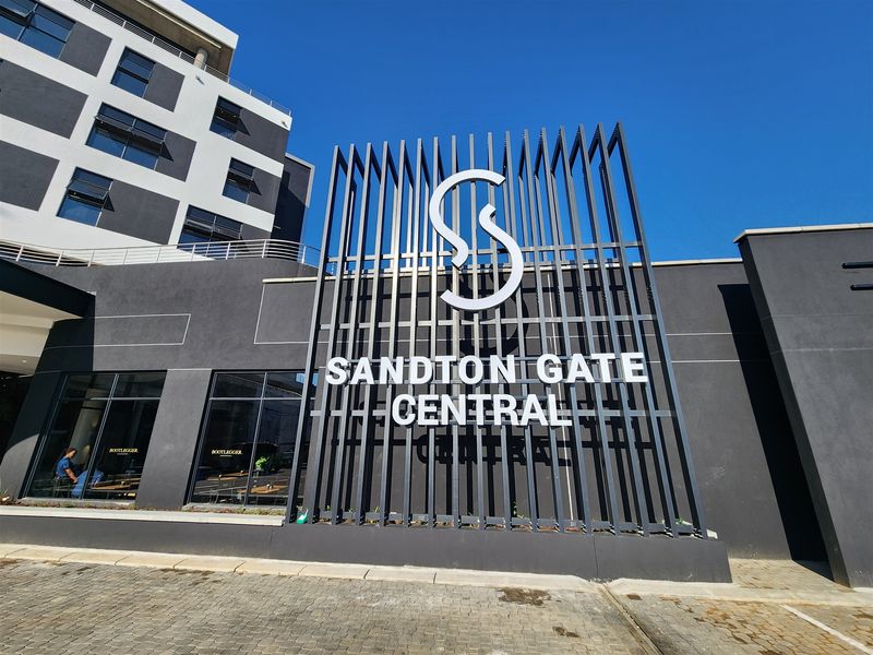 Modern office building exterior featuring prominent Sandton Gate Central signage and contemporary architectural design with large glass windows.