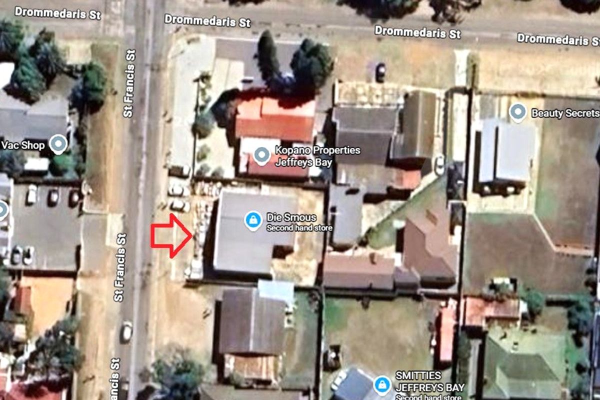 An aerial satellite view showing the property layout, roof structure, and surrounding street access in a commercial retail area.