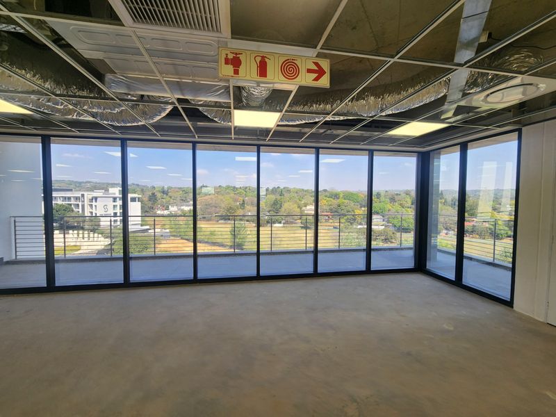 Unfinished open-plan office space featuring floor-to-ceiling windows, balcony access, and exposed ceiling infrastructure, offering a blank canvas for custom fit-out.