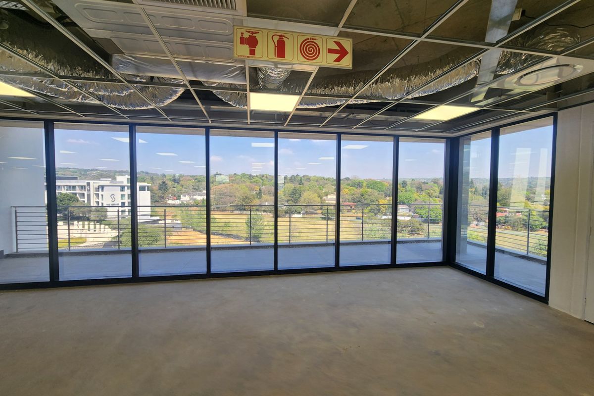 Unfinished open-plan office space featuring floor-to-ceiling windows, balcony access, and exposed ceiling infrastructure, offering a blank canvas for custom fit-out.