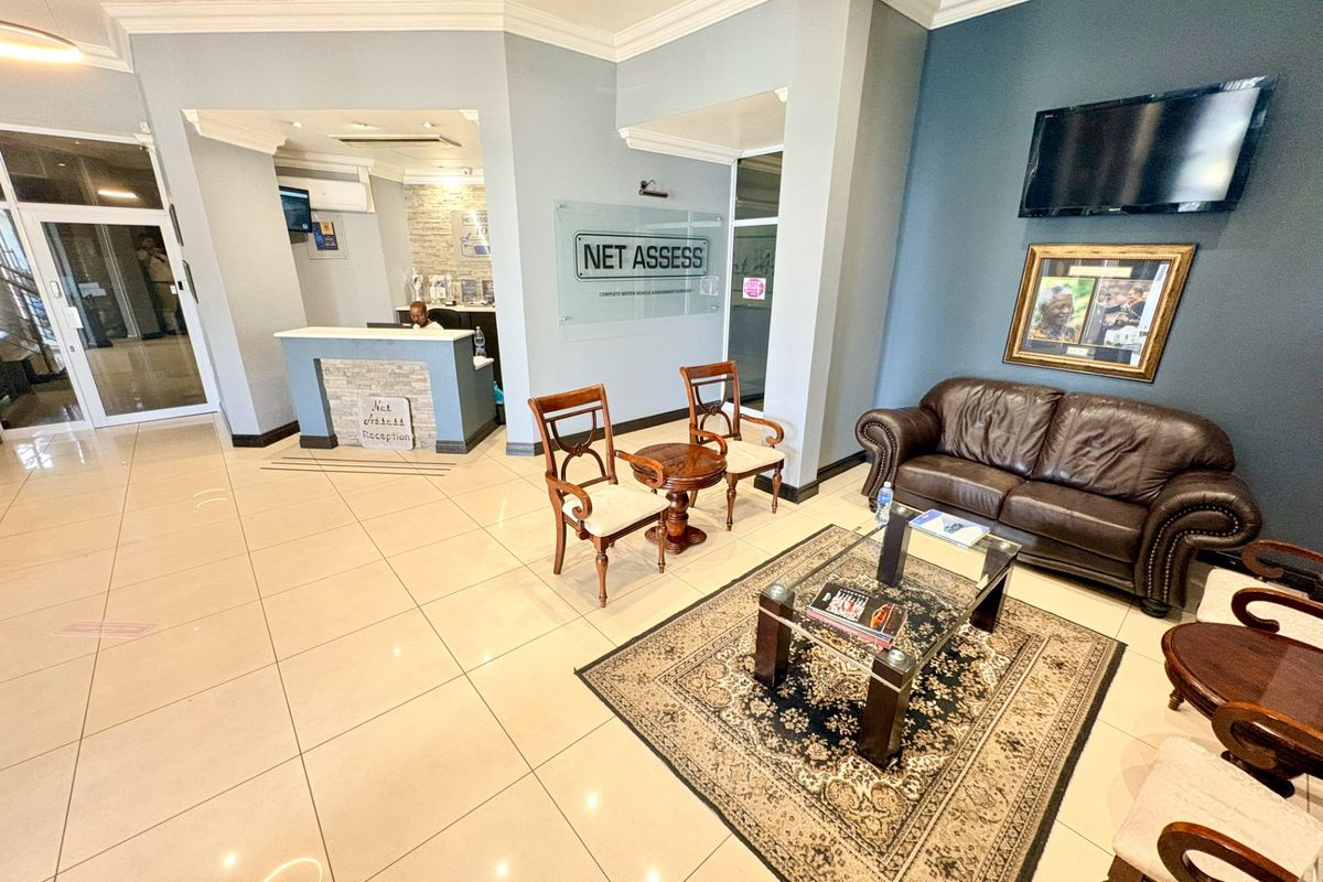 A professional office reception area featuring tiled flooring, a dedicated reception desk, and a comfortable waiting lounge with modern finishes.