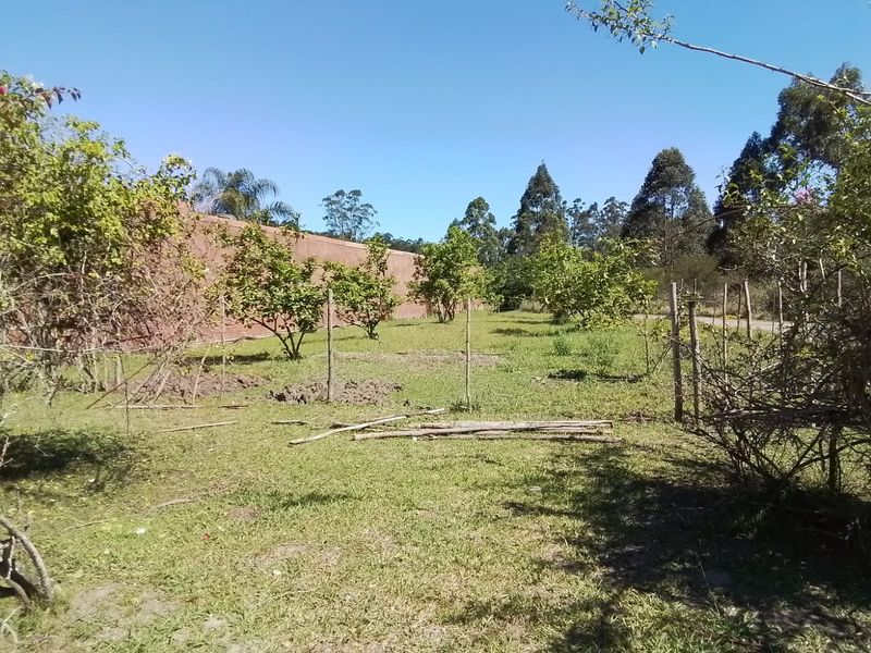 A large, open garden area on the farm property featuring a perimeter wall and basic wire fencing, requiring landscaping and maintenance.