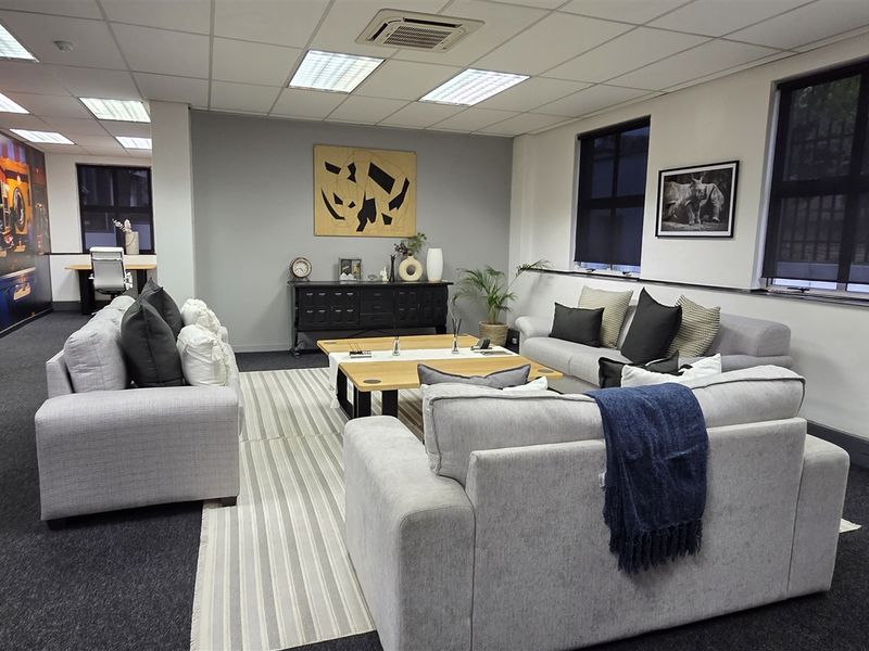 A spacious, well-maintained office area featuring a suspended ceiling with recessed lighting, ducted air conditioning, and carpeted flooring.