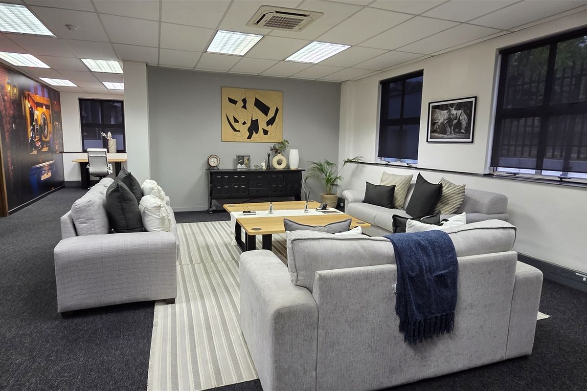 A spacious, well-maintained office area featuring a suspended ceiling with recessed lighting, ducted air conditioning, and carpeted flooring.