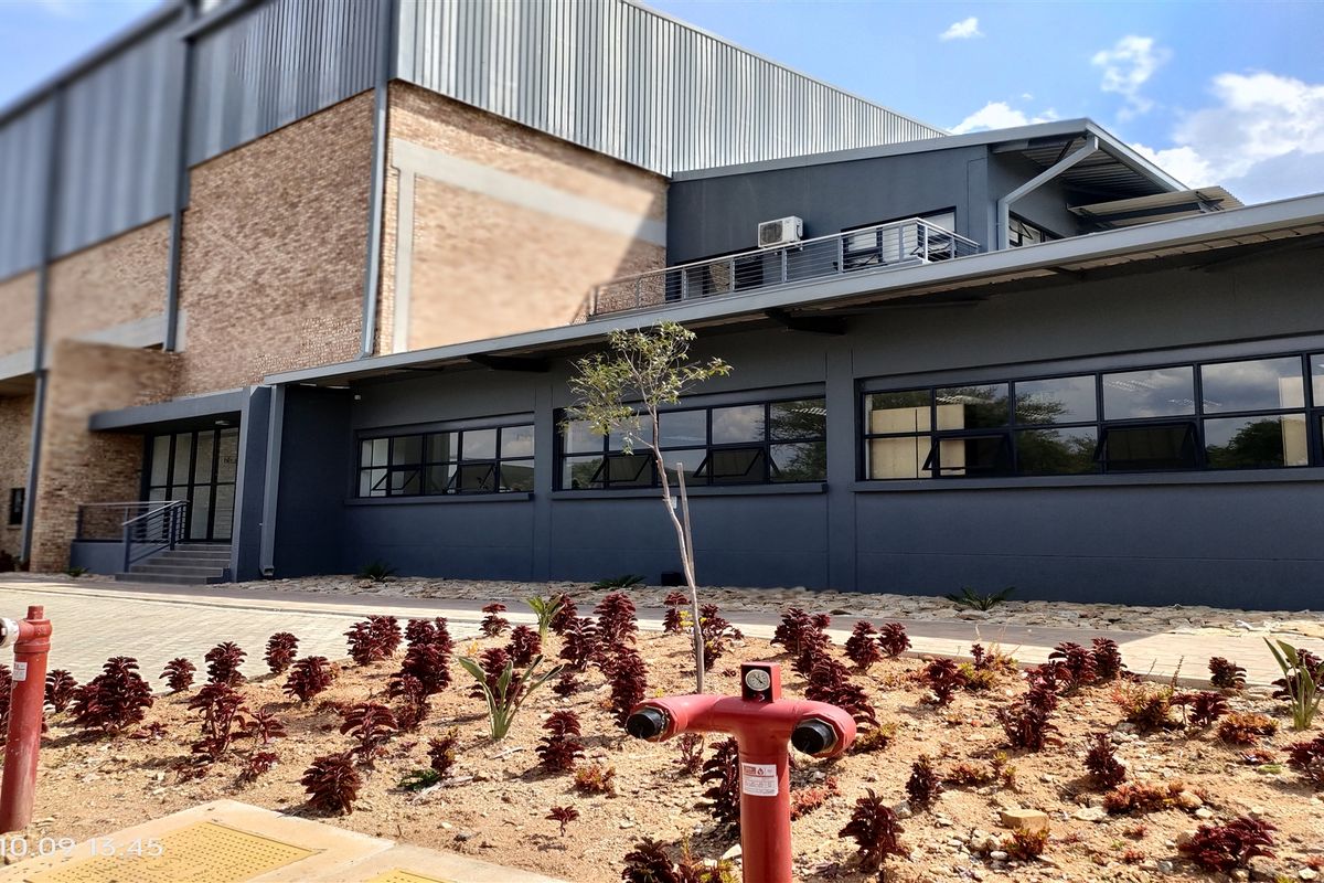 Modern industrial building exterior featuring a combination of brick and dark metal cladding, large windows, and integrated fire safety infrastructure.