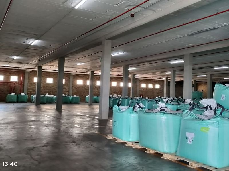 Spacious industrial warehouse area featuring concrete flooring, exposed sprinkler systems, and structural columns, suitable for storage or logistics operations.