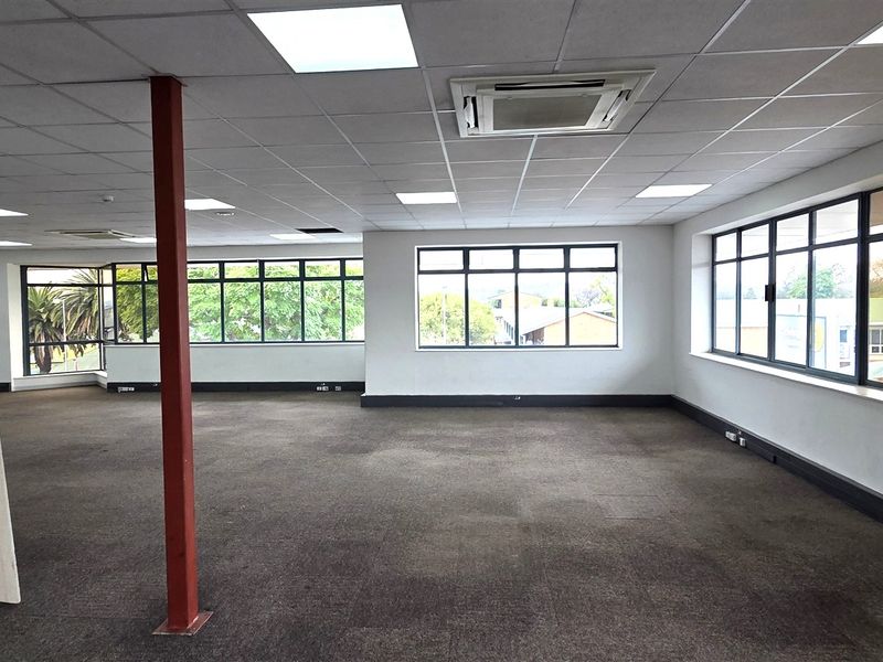 Spacious, open-plan office area featuring large windows, suspended ceilings with integrated lighting, and central air conditioning, offering a versatile workspace.